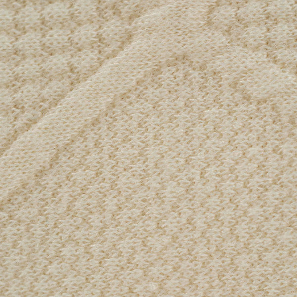 Close-up of oatmeal knit baby blanket showing soft textured knit pattern and warm neutral color