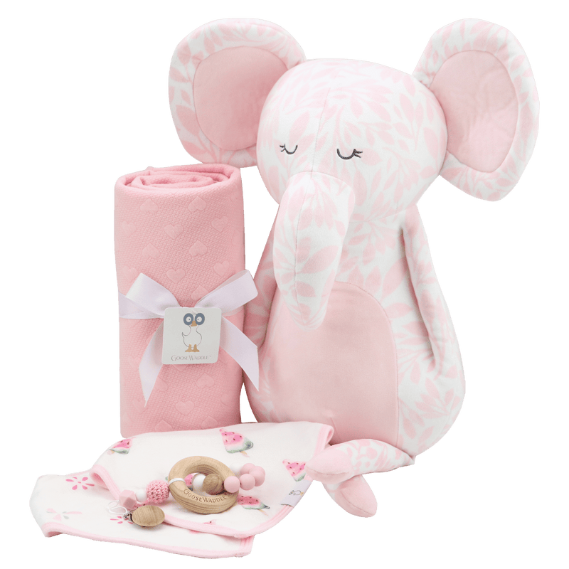The Pink Knit Blanket paired with a plush elephant toy and baby accessories, suitable for gifting and nursery decor.