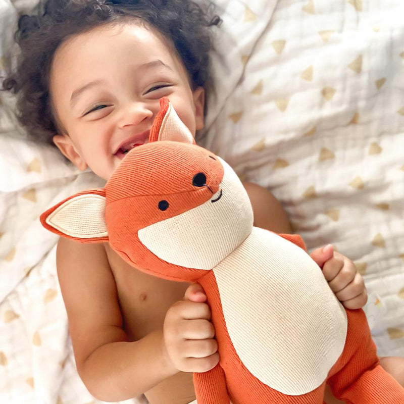 A joyful child hugging the Fox Knit Plush, illustrating how this soft toy becomes a loving companion for playtime.