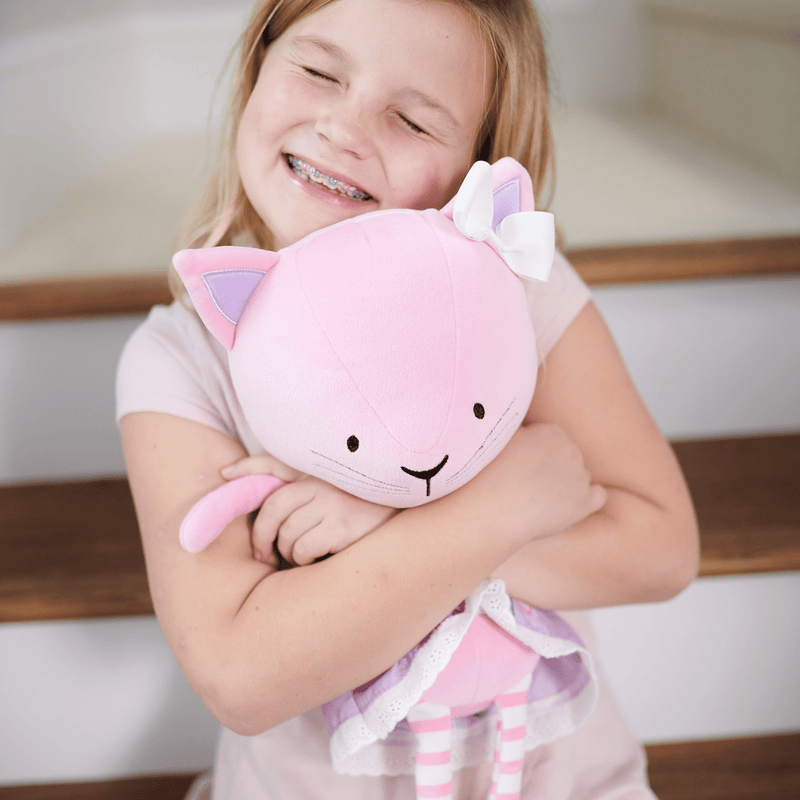 Lucy Kitty Plush Doll with Dress being hugged by a smiling girl, showcasing the doll's soft design and playful expression.