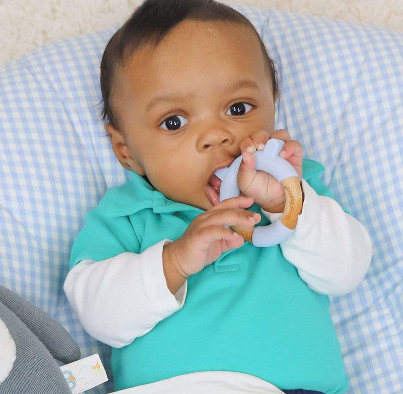 A baby enjoying the Blue Bear Circle Bear Head Teether Silicone + Wood Teether, highlighting its safe and soft features for teething relief.