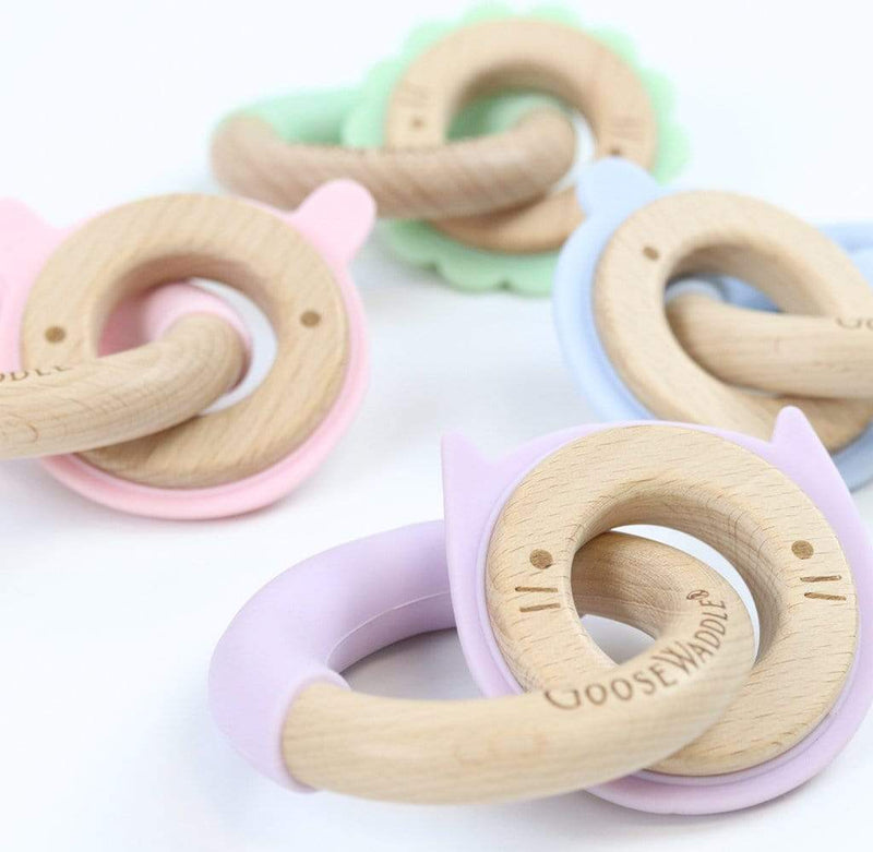 Colorful assortment of Lavender Kitten Silicone + Wood Double Teethers in various pastel colors, including lavender and pink, showcasing their playful design and baby-friendly materials.