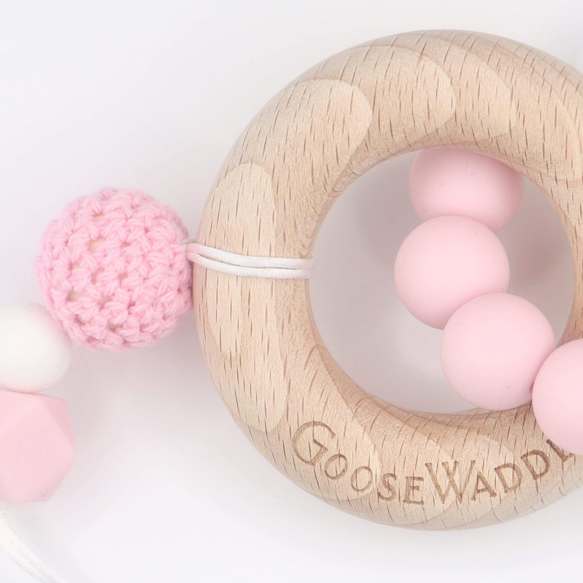 Wooden and Silicone Teether - Pink: a wooden ring with pink silicone beads and a crocheted pink ball, clip-fastened.