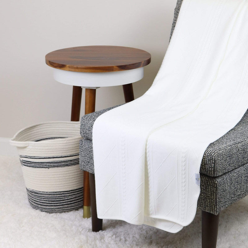 Cozy White 50" x 60" Full Size Knit Throw by Goosewaddle® draped over a stylish chair next to a wooden side table and woven basket.