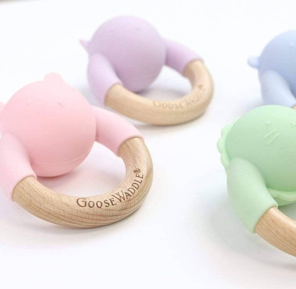 Pink, purple, green, and blue wooden silicone baby teether rings with smooth wooden handles and soft silicone animal shapes