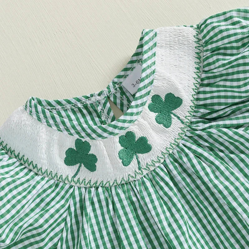 Green check smocked romper made of soft cotton with embroidered shamrock details on white smocked bodice