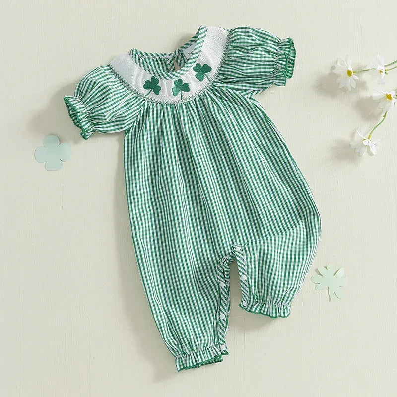 Green check smocked romper made of soft cotton with embroidered clover detail and puff sleeves