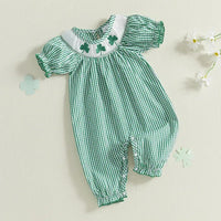 Green check smocked romper made of soft cotton with embroidered clover detail and puff sleeves