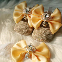 gold glitter baby shoes and yellow satin bow headpiece set for babies with rhinestone crown detail