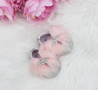 pink baby shoes with rhinestone details and pink fluff for infants near pink flowers
