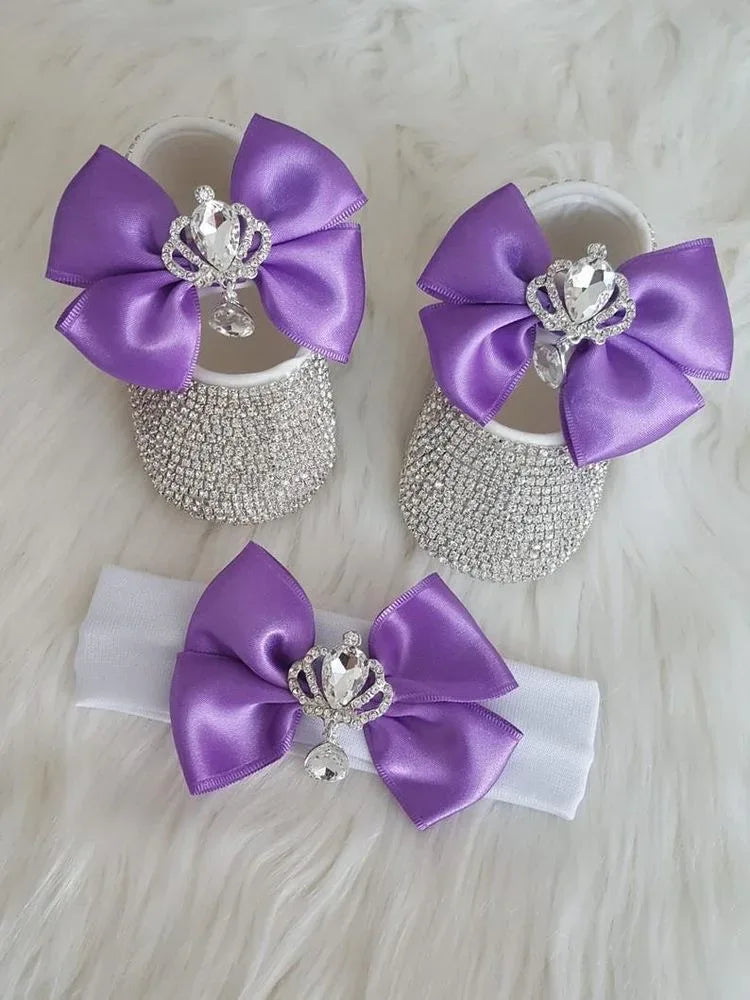 Purple headpiece set for babies with satin bows and rhinestone crowns featuring baby shoes and a white headband