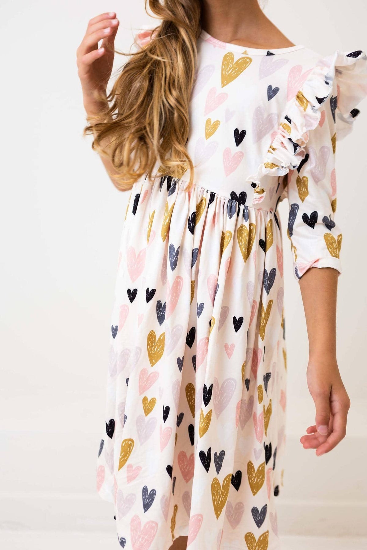 girl wearing white heart print ruffle twirl dress with sleeves
