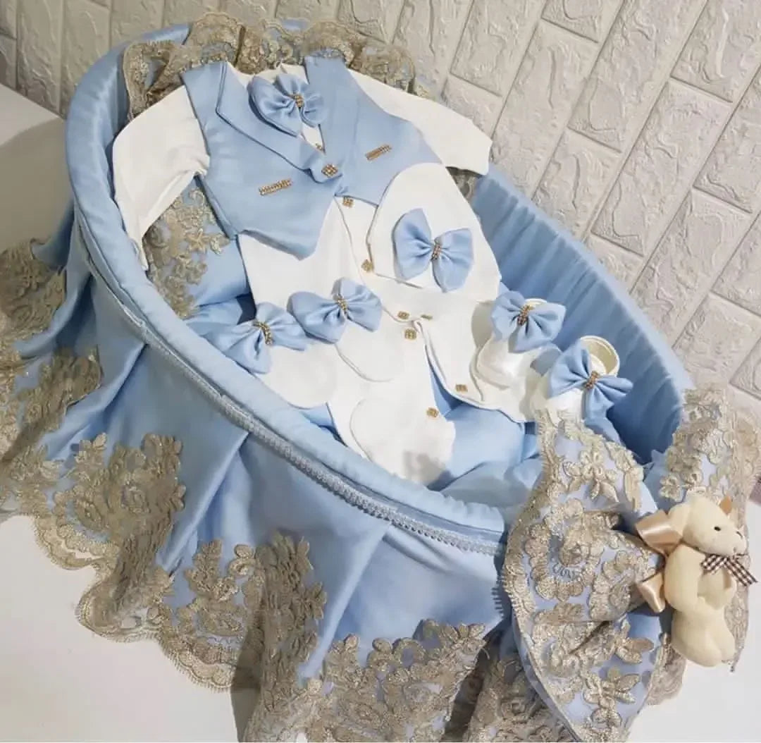 blue and white homecoming baby outfit set for newborns with bow ties and lace detailing in bassinet