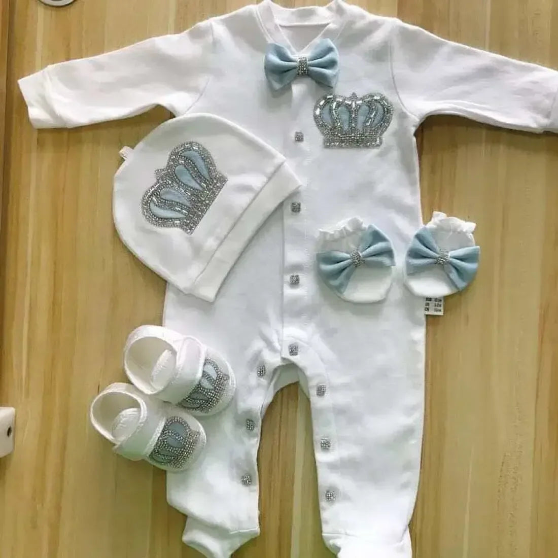 White homecoming baby outfit set with blue bows and rhinestone crown details for newborns