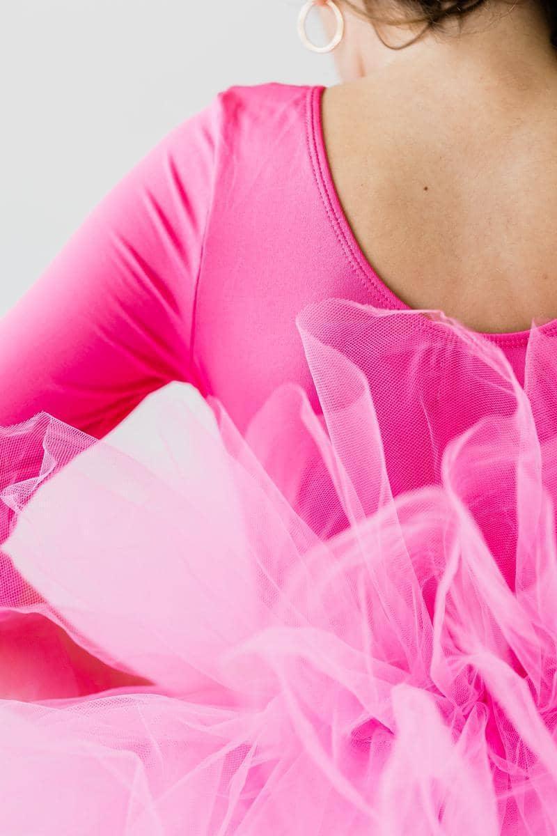Close-up of girl wearing hot pink tutu leotard for girls with sleeves and layered tulle skirt