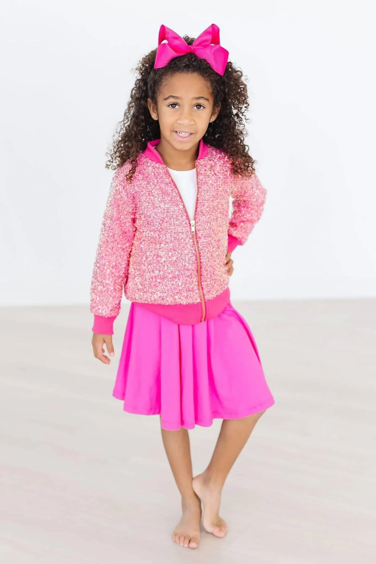 girl wearing hot pink twirl skort for girls standing with hand on hip and smiling