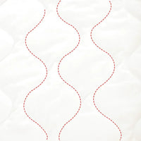 close-up of white quilted fabric with red stitched lines for zippered sleeping bag for kids