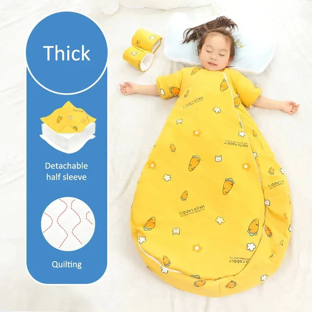 Toddler girl lying down wearing yellow zippered sleeping bag for kids with carrot print and detachable sleeves