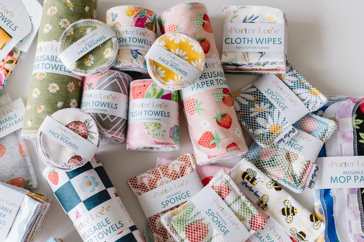 Assorted reusable products including paper towels, cloths, and sponges with colorful packaging.