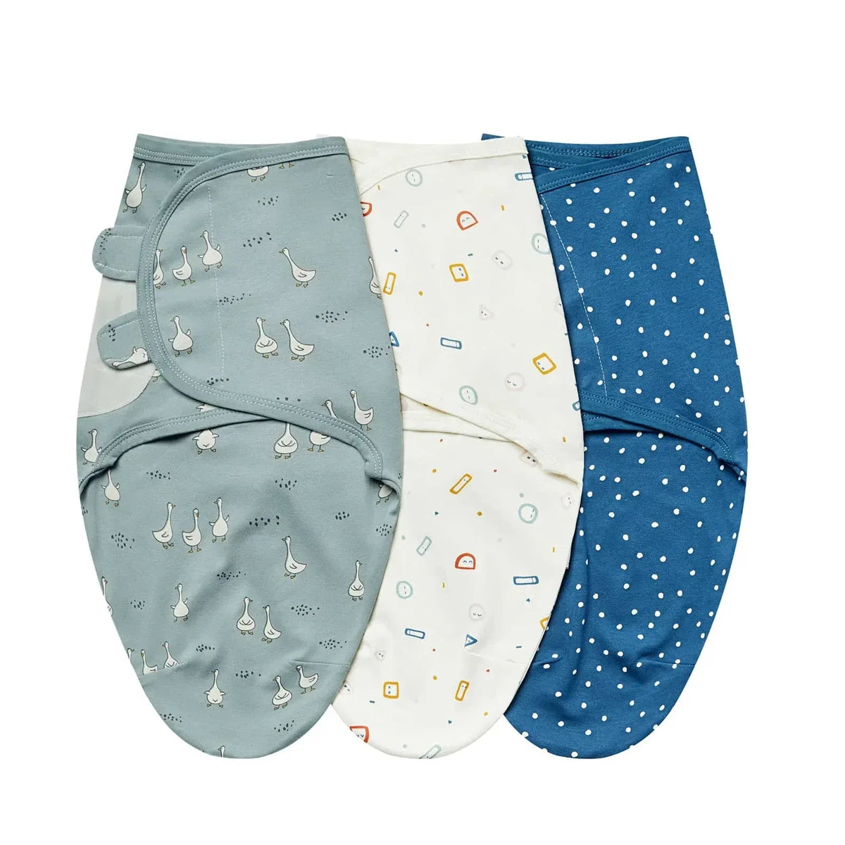 Set of three cotton swaddle bags for babies in blue, white with colorful shapes, and gray with duck prints