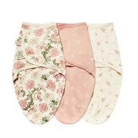 Set of three cotton swaddle bags for babies in pink floral, solid dusty rose, and cream with small yellow prints