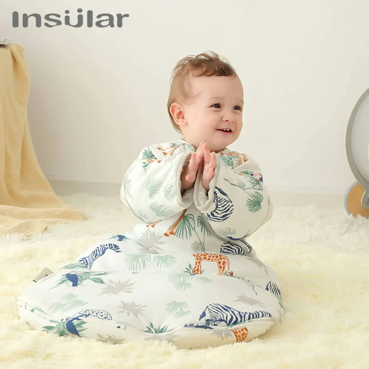 White cotton toddler sleep sack with zipper featuring colorful jungle animal prints worn by smiling baby