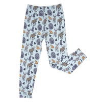 Light blue kids pajama pants featuring a woodland print of moose, deer, bears, foxes, and black cats with fern leaves.