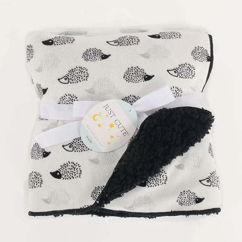white and black cozy fleece baby blanket for newborns with hedgehog print and black sherpa lining