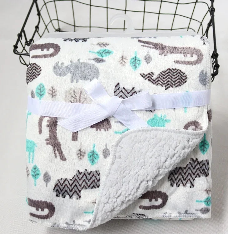 White cozy fleece baby blanket with gray and teal animal prints, perfect for infants and toddlers