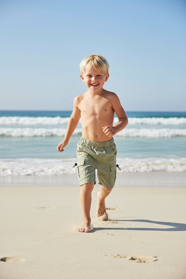 Light green toddlers boys cargo shorts with pockets laid flat showing elastic waistband and side details