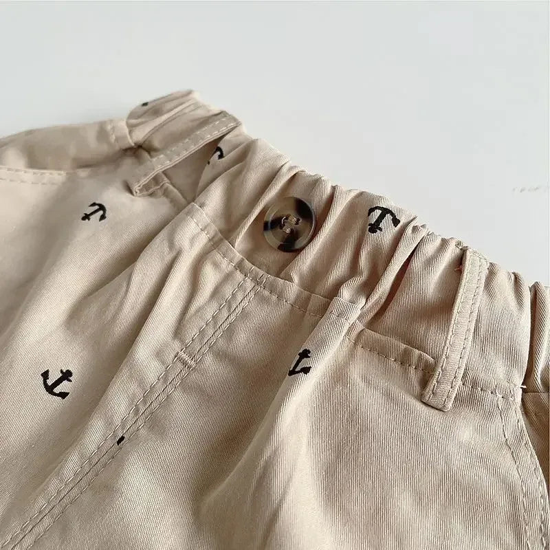 Close-up of beige kids khaki shorts set with small black anchor prints and button detail