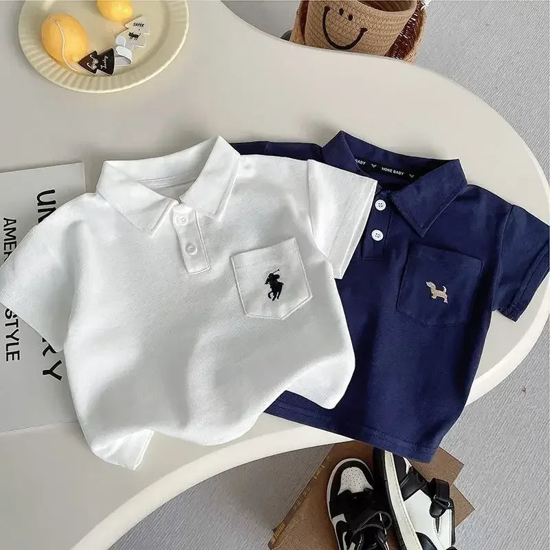 Two kids khaki shorts set tops in white and navy polo shirts for toddlers displayed on table