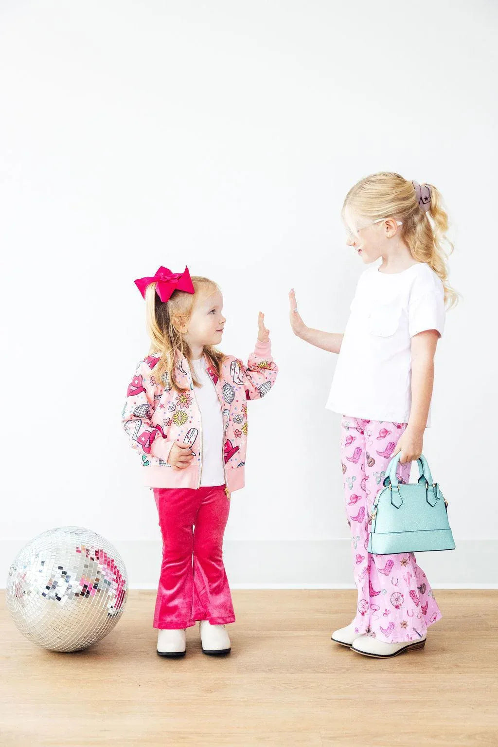 Girls pink satin jacket with floral pattern, toddler size, worn with red pants and bow