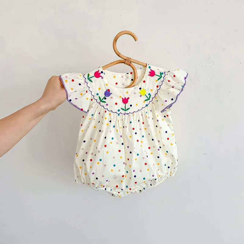 baby white polka dot romper with colorful floral embroidery and ruffled sleeves for infants