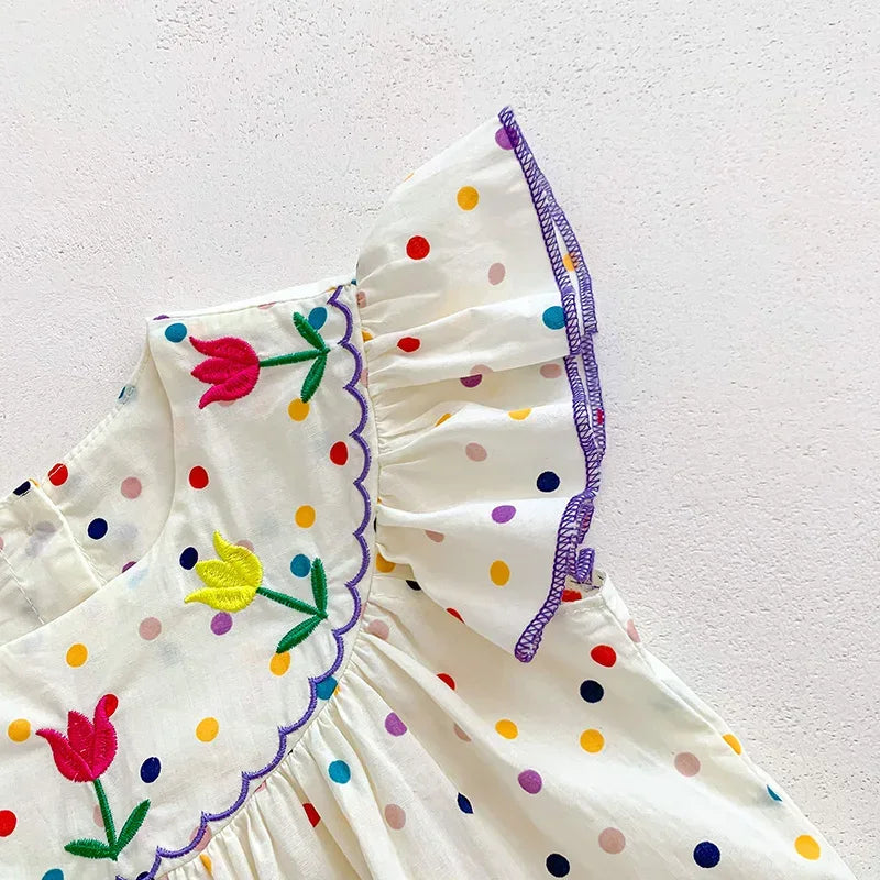 Baby white polka dot romper with colorful embroidered tulips and purple scalloped trim on sleeve