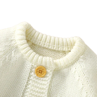 cream knit romper set for babies with wooden button detail on round neckline