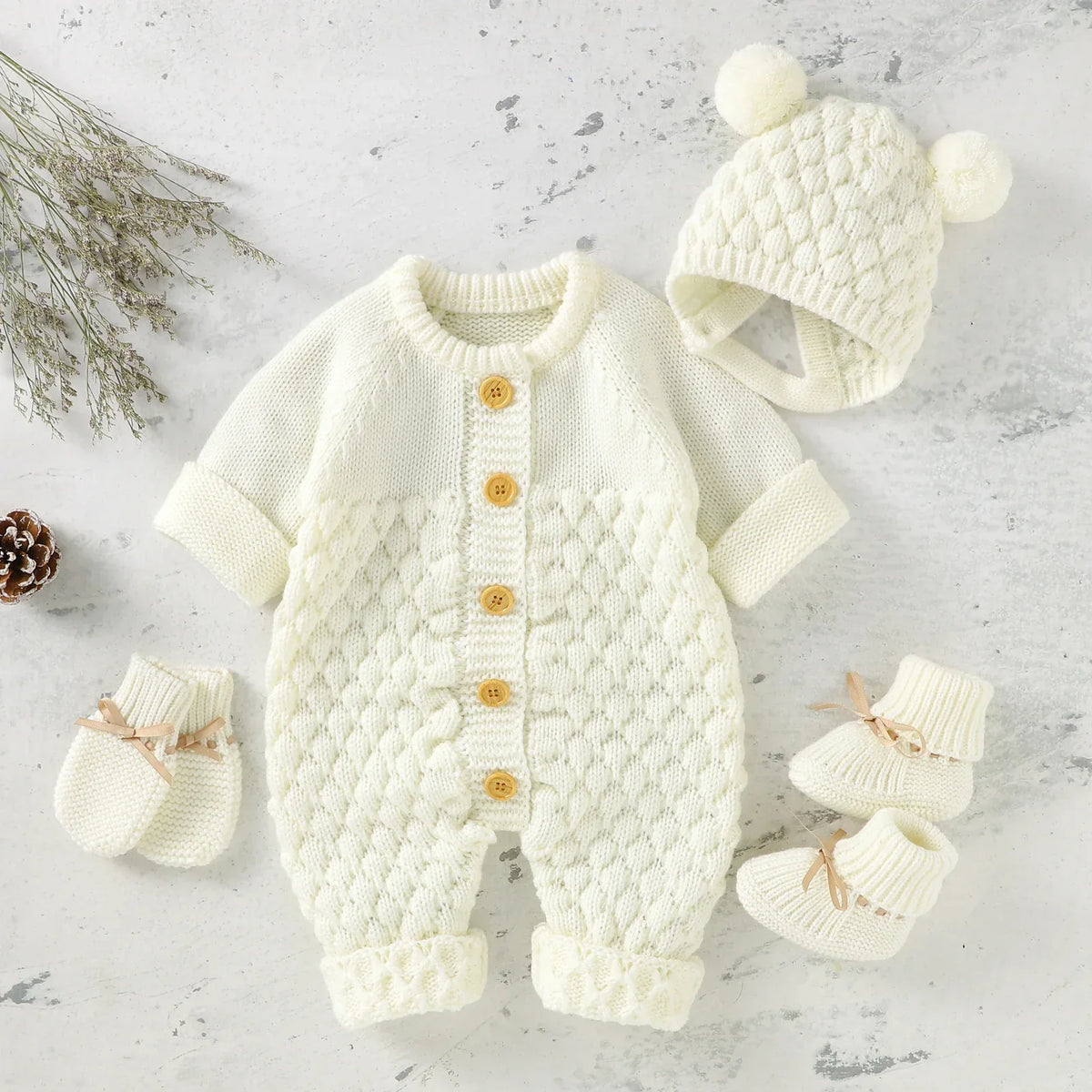 Cream knit romper set for babies with wooden buttons and matching hat with pom poms