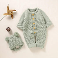 Baby green knit romper set with honeycomb pattern and yellow buttons with matching pom pom hat