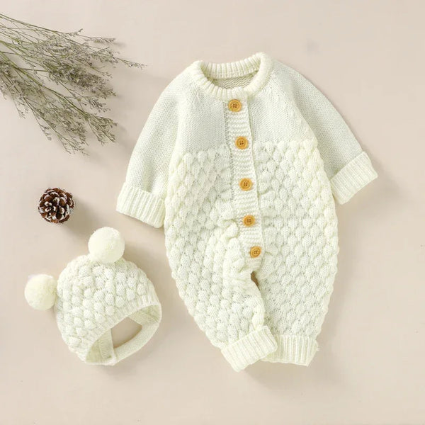 cream knit romper set for babies with wooden buttons and matching pom pom hat