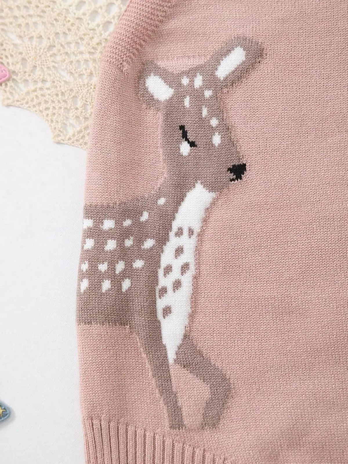 Close-up of pink knitted baby bubble romper with a brown and white deer design for infants
