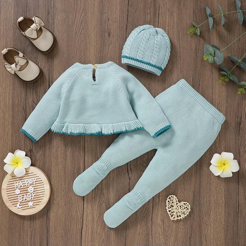 Light blue knitted baby outfit set with ruffle hem sweater, footed pants, and cable knit hat for infants