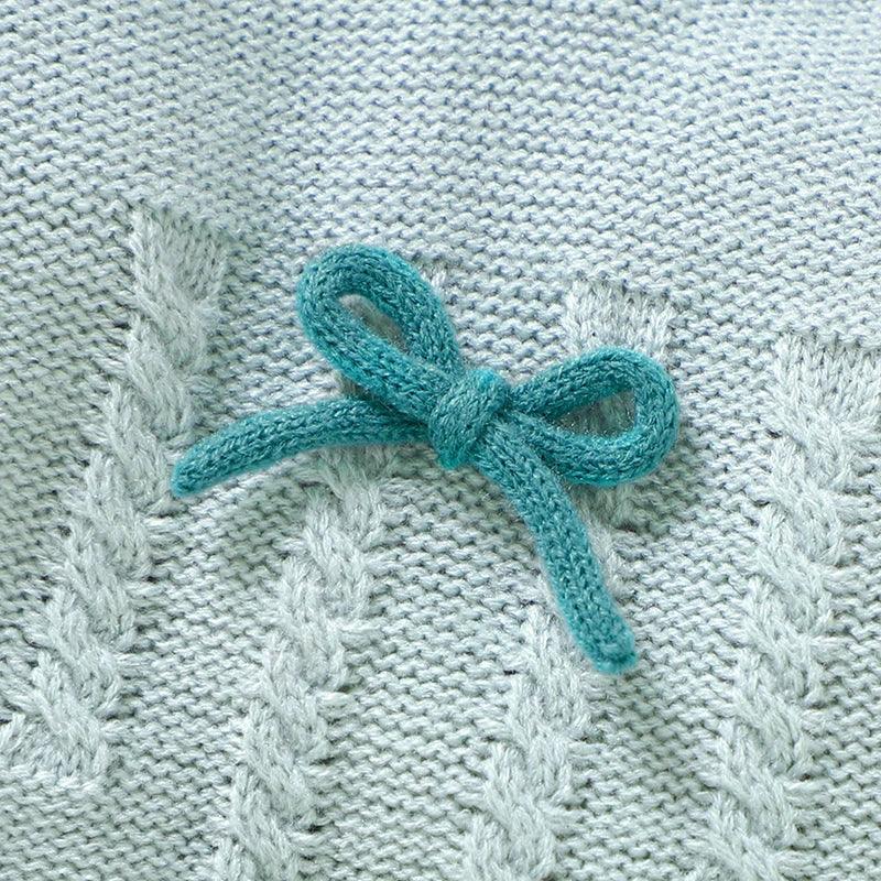 Light blue knitted baby outfit set with cable knit pattern and teal bow detail for infants