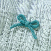 Light blue knitted baby outfit set with cable knit pattern and teal bow detail for infants