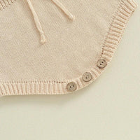 beige knitted baby romper for infants with three wooden buttons and drawstring detail
