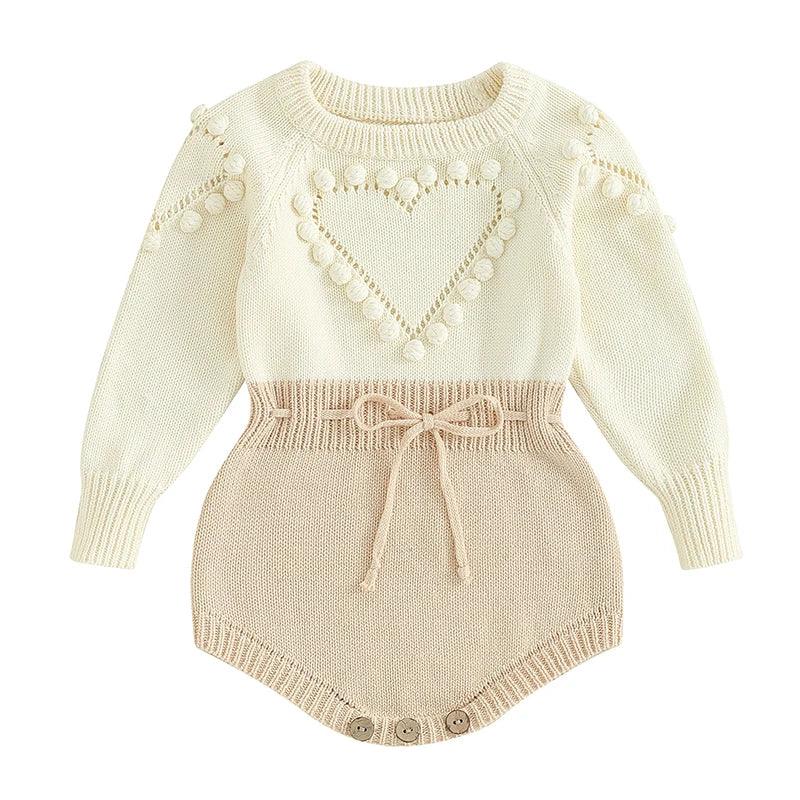 cream and beige knitted baby romper with heart pattern and pom pom details for babies