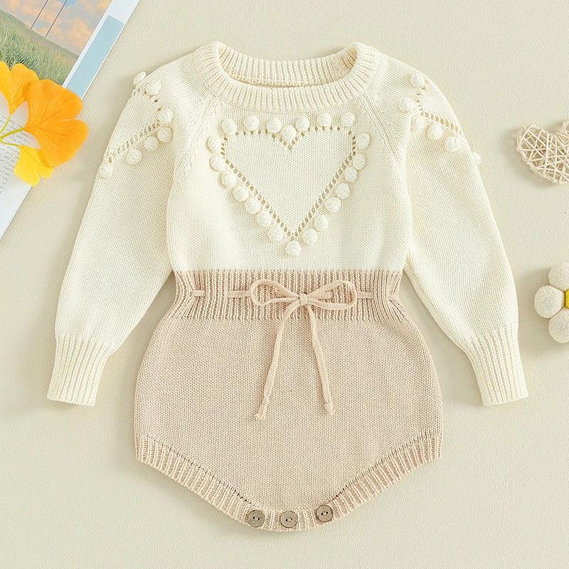 Cream and beige knitted baby romper for infants with heart pattern and pom pom details