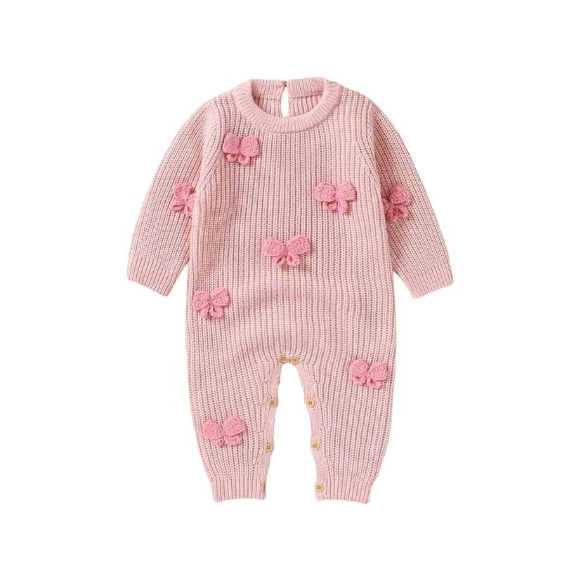 pink knitted baby romper with bows for infants featuring long sleeves and button snaps