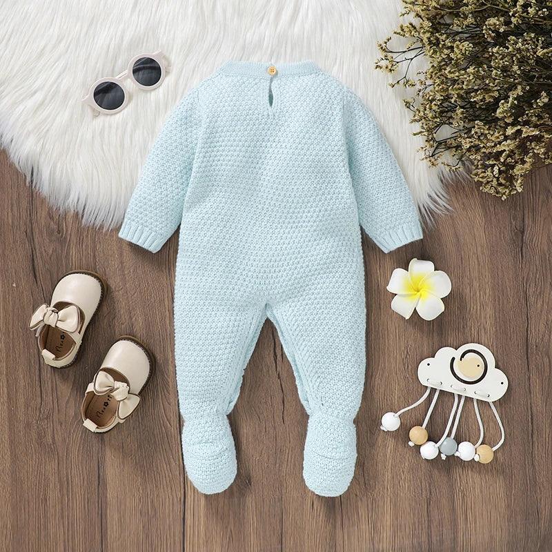Light blue knitted baby romper with feet laid flat for newborn to 3 months with long sleeves