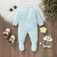 Light blue knitted baby romper with feet laid flat for newborn to 3 months with long sleeves