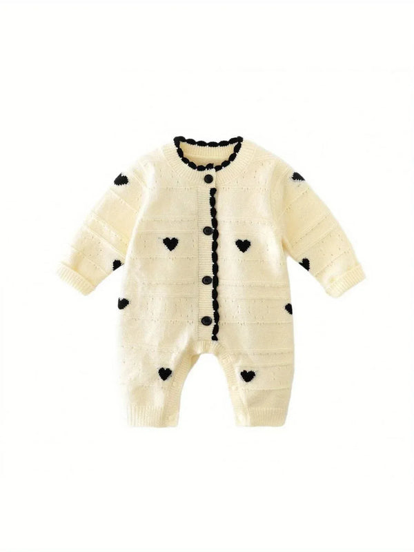 Cream knitted baby romper with hearts in black for infants with button front and long sleeves